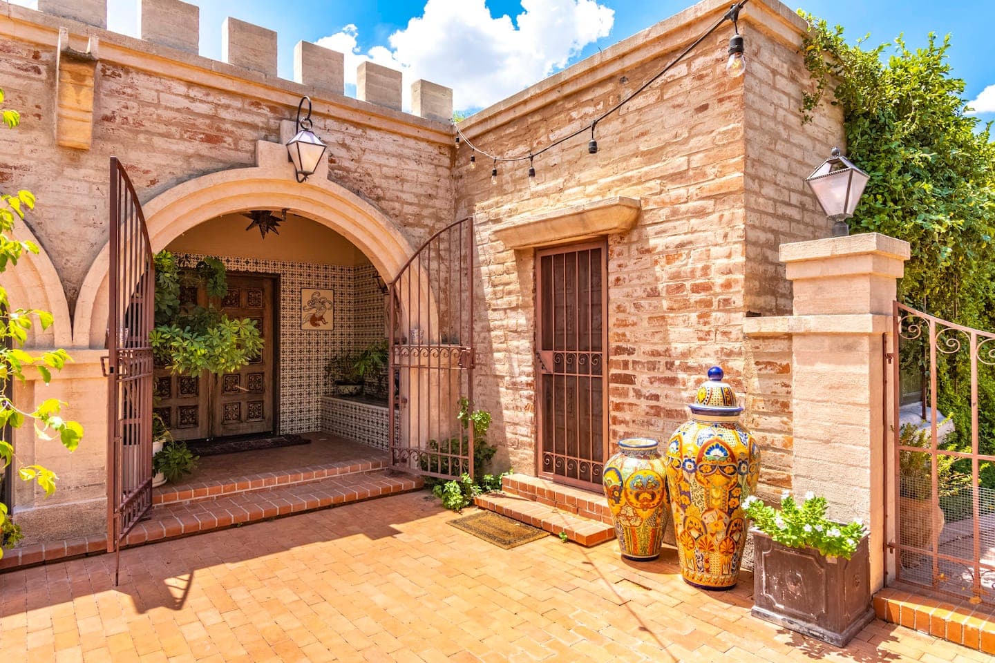 Azul Courtyard Suite: entrance courtyard with arched carved-wood doors and talavera urns